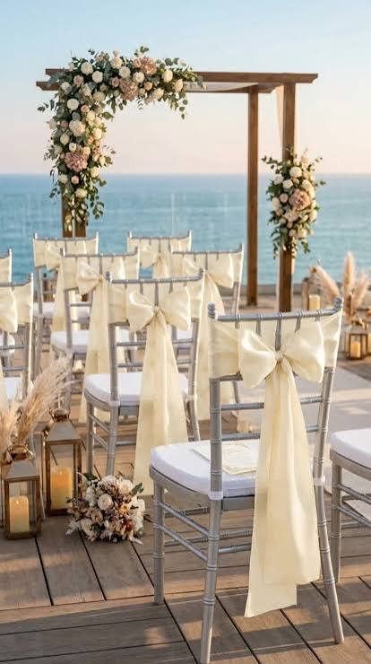 Coastal wedding ceremony arch dressed in white blooms